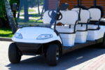 White multi-seat golf cart parked outdoors.