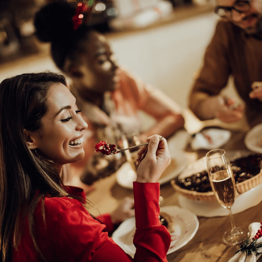 A woman enjoys dinner with friends. 