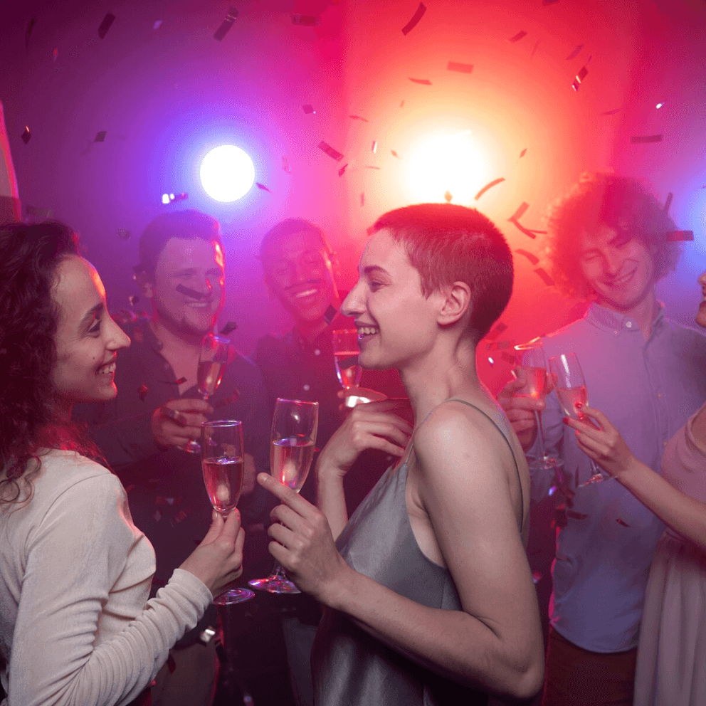 Two women dance and drink at a party. 
