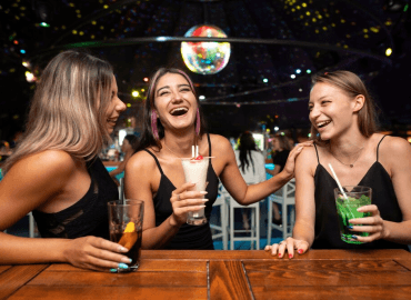 Three women enjoying drinks after a college bowl game