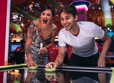 Image of a couple playing air hockey.