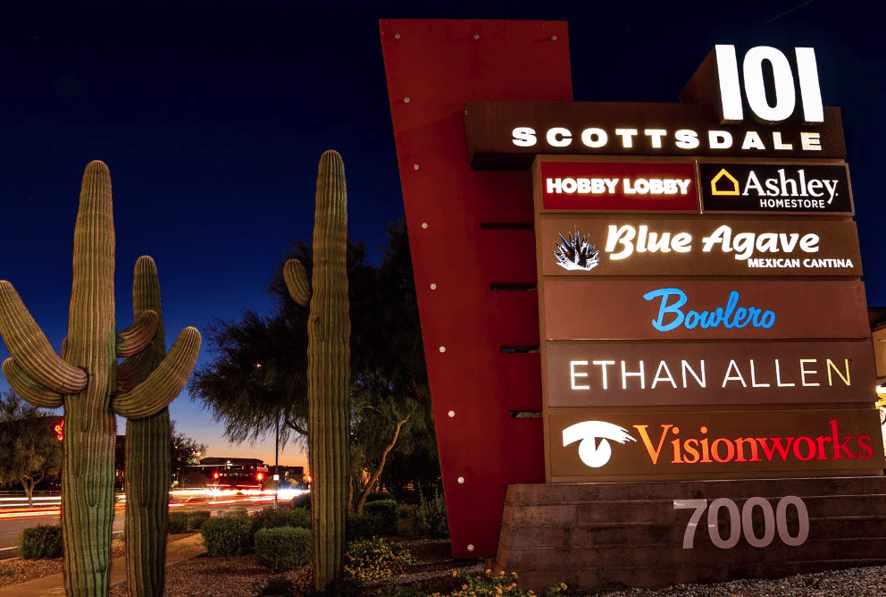 A night time image of the store sign at Scottsdale 101 Shopping Center.
