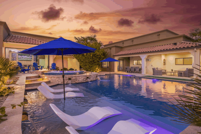 A luxury vacation retreat with a backyard pool and lounge chairs. 