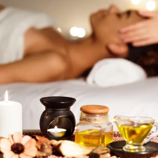 A relaxing personal massage setting with lit candles, essential oils, and spa essentials.