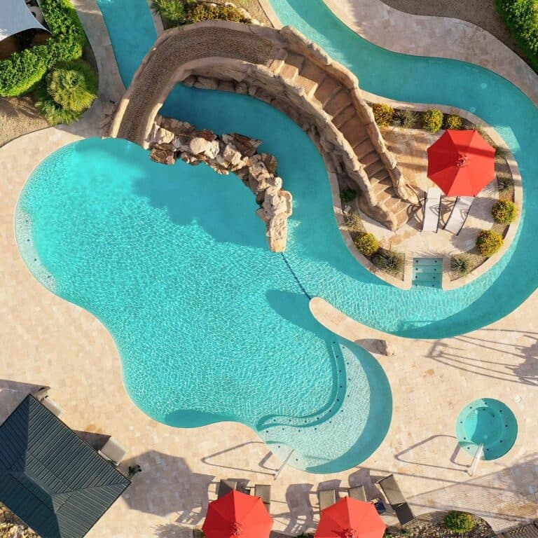 Aerial view of a resort pool, lazy river, and outdoor lounge at HÓZHÓ Estates at Lone Mountain