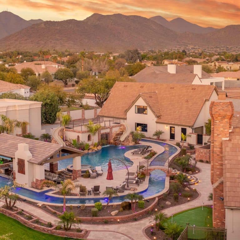 Sunset view of the Grand Estate on Sunnyside pool, outdoor pavilion, and desert mountains