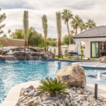 A private pool beside a luxury vacation rental on a sunny day.