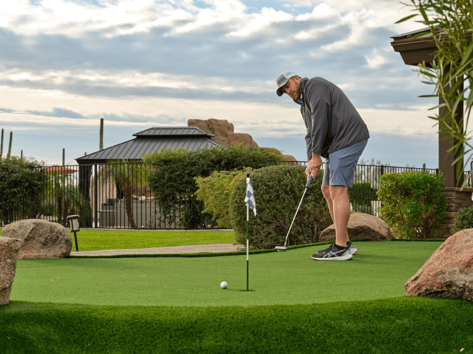 Image of a man golfing on the putting green at HÓZHÓ Main Estate at Lone Mountain.