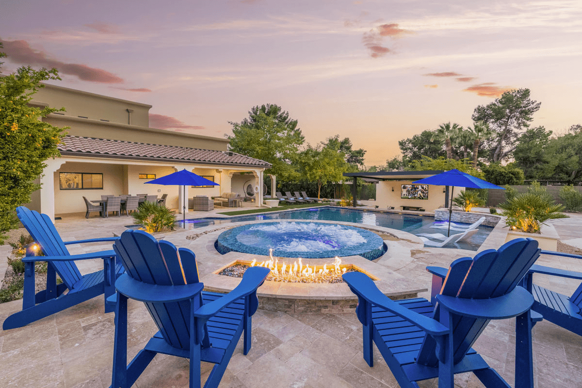 Blue chairs around a fire pit and hot tub.