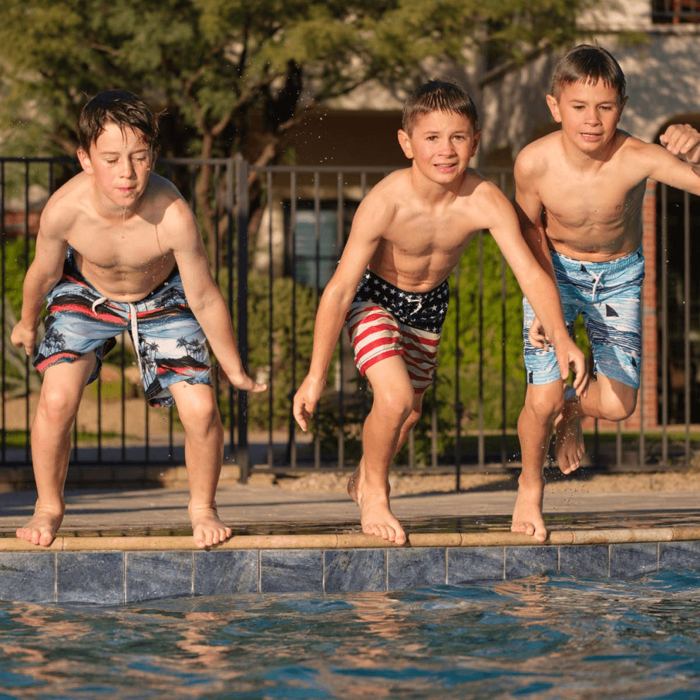 An image of three boys jumping into a HÓZHÓ Scottsdale pool.