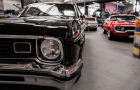 Close-up of a black vintage car with classic cars in the background.