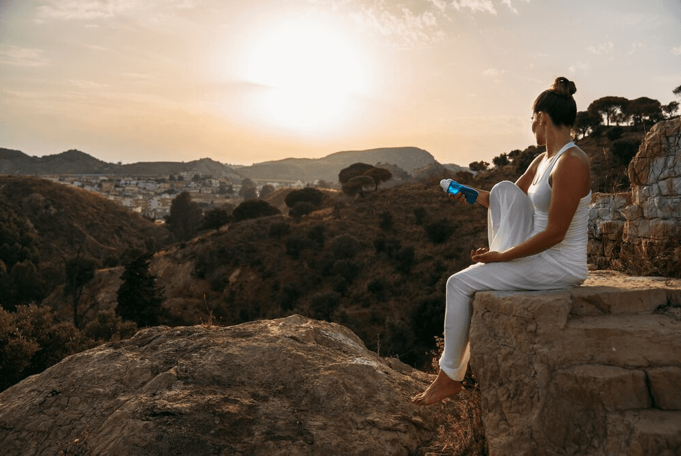 A woman sits on the edge of a platform to mediate.