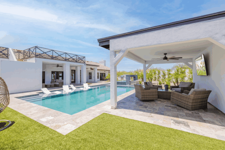A modern backyard with a pool and lounge area.