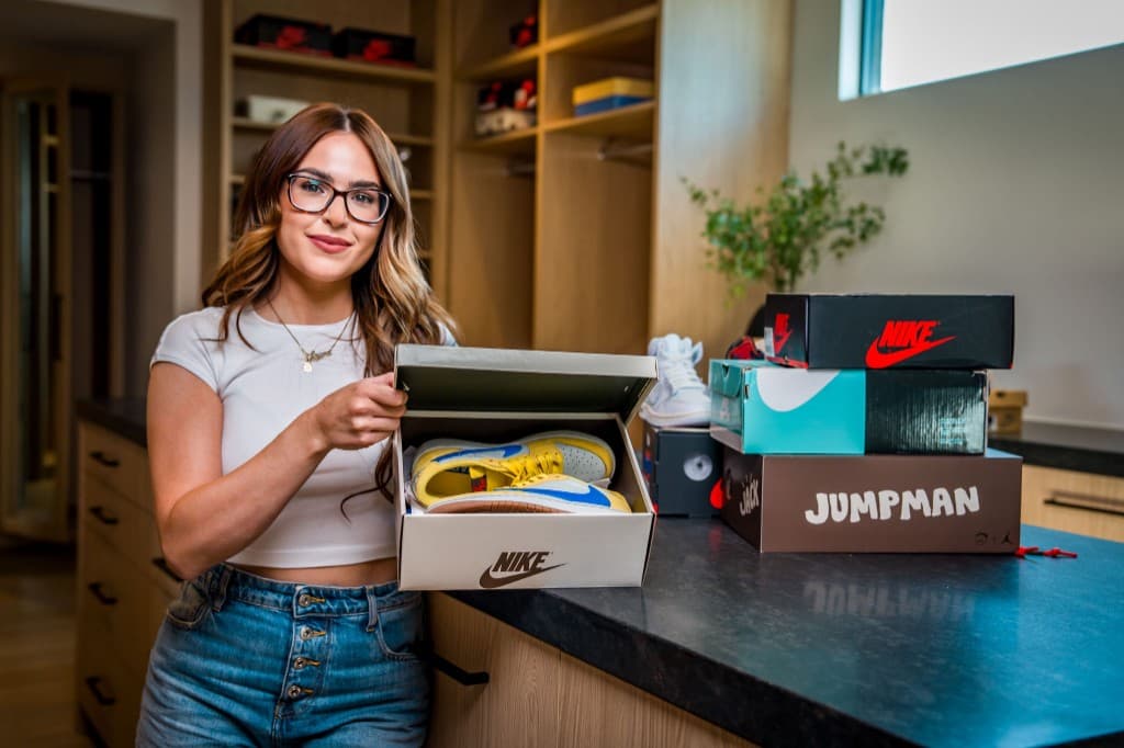 Laura Laces unboxing sneakers in her walk-in closet