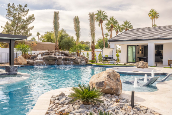 A private pool beside a luxury vacation rental on a sunny day.