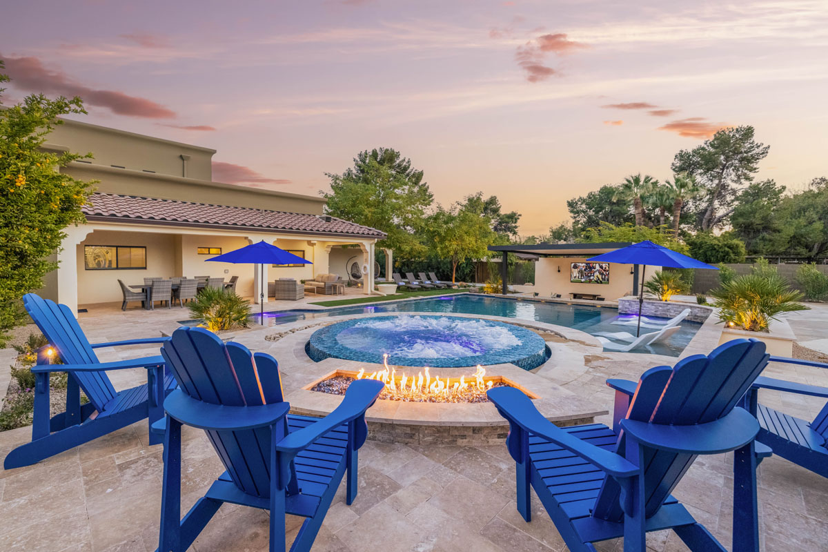 Blue chairs around a fire pit and hot tub.
