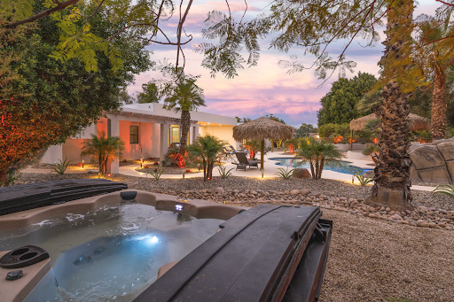 A backyard view of a house with an above-ground hot tub.