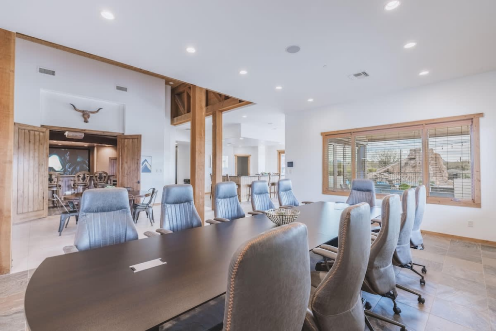 An image of a large table with office chairs inside a large home. 
