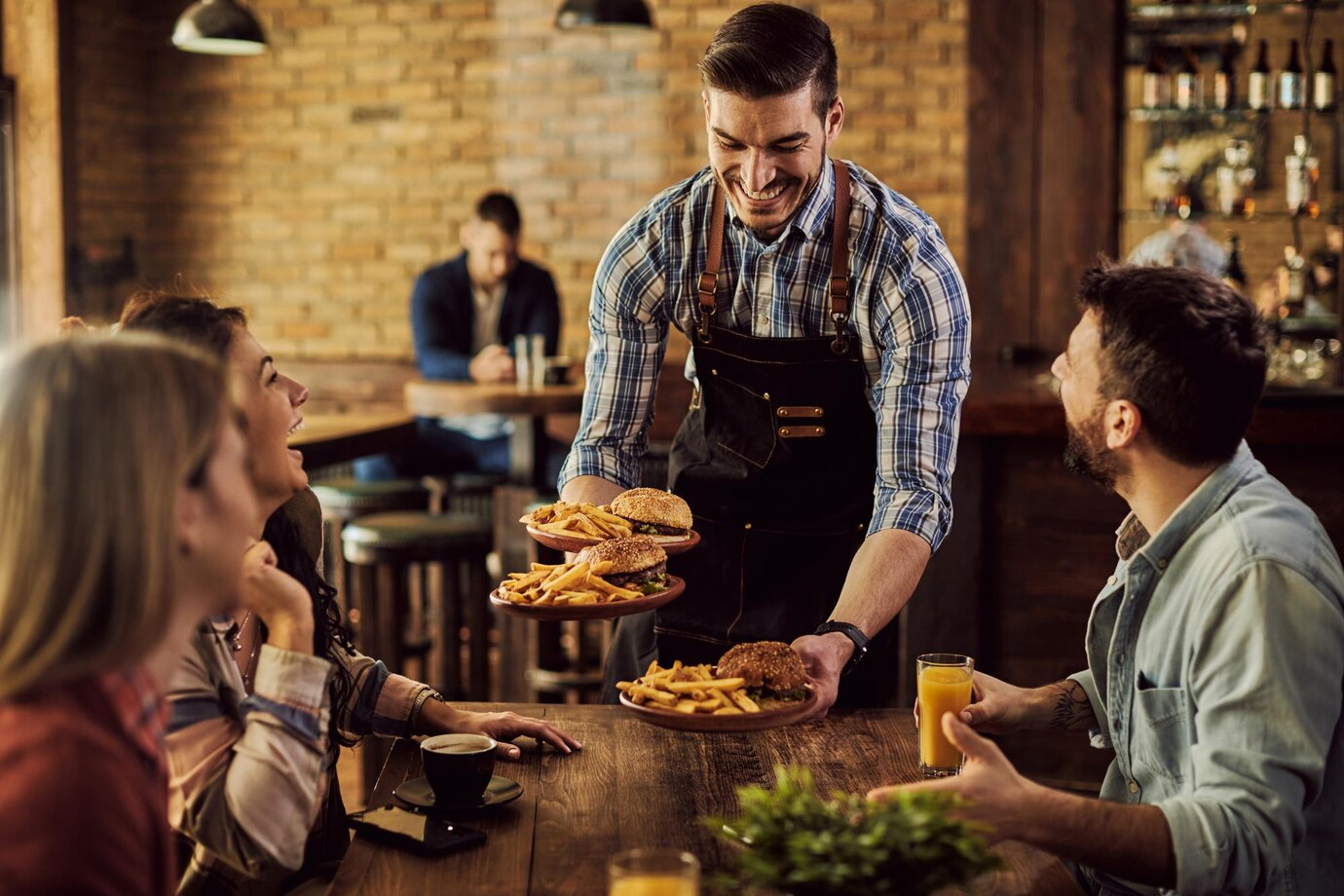An image of a waiter serving a table of people.