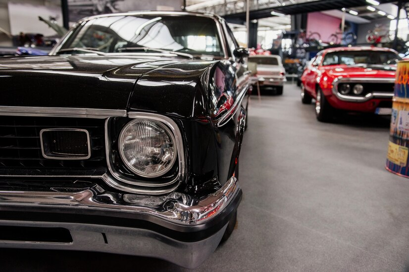 Close-up of a black vintage car with classic cars in the background.