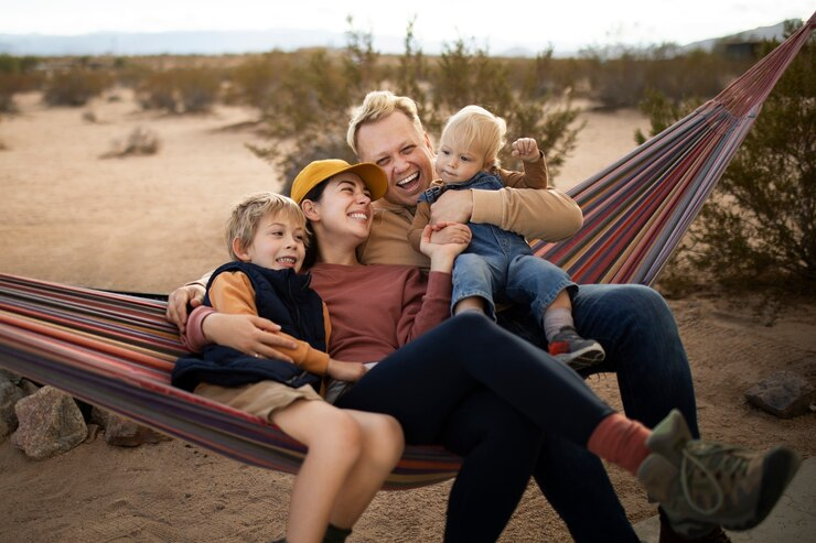 A family hanging out together on a hammock. 