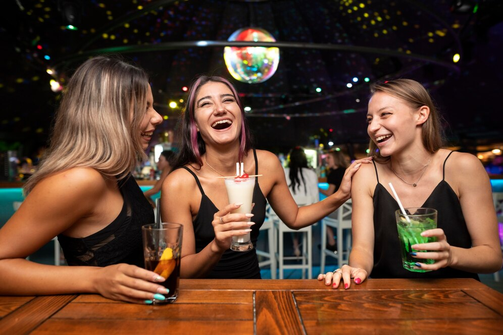 Three women enjoying drinks after a college bowl game
