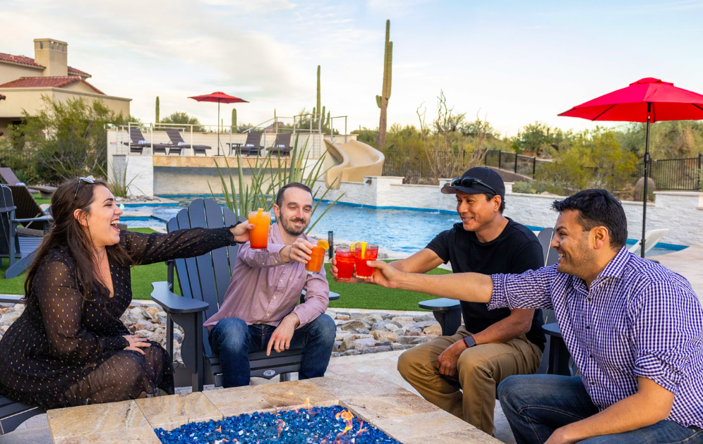 Family enjoying a drink by the pool at HÓZHÓ Estates at Lone Mountain.