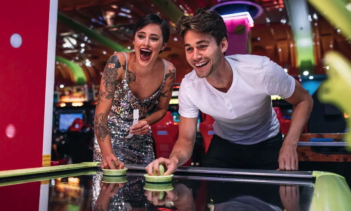 Image of a couple playing air hockey.