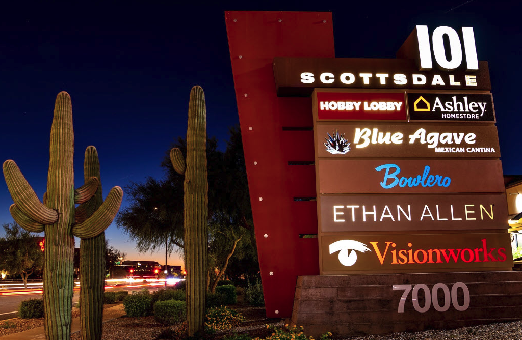 A night time image of the store sign at Scottsdale 101 Shopping Center.