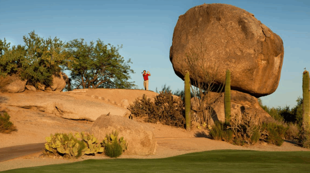 Boulders Club - A golfer hitting a shot beside a boulder at one of the golf courses in Scottsdale Arizona.