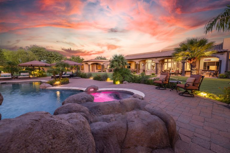 A resort-style backyard with a heated pool, spa, water features, covered ramada, and more.