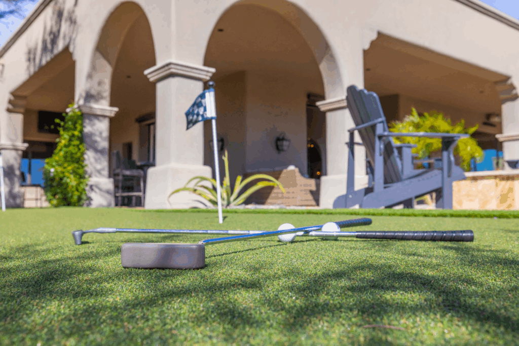 Golf clubs on a putting green outside a house at a luxury travel destination.
